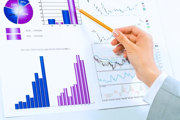 Női kéz mutató ceruza, a pénzügyi diagramokat — Stock Fotó