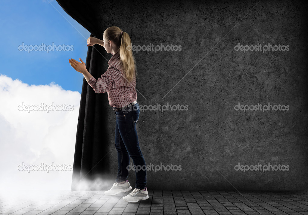 young woman pushes the curtain looking at clouds