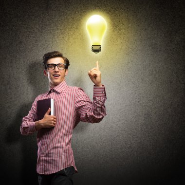 Elinde kitap tutan genç bir adam.