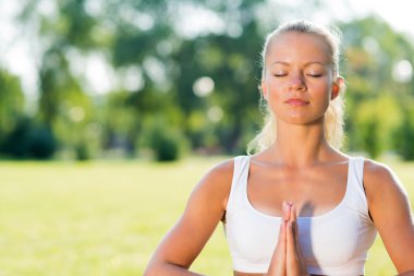 Parkta yoga yapan kadın.