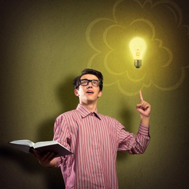 Elinde kitap tutan genç bir adam.