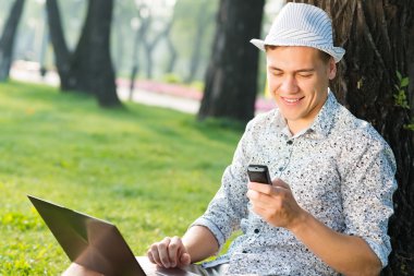 Cep telefonu olan genç bir adam.