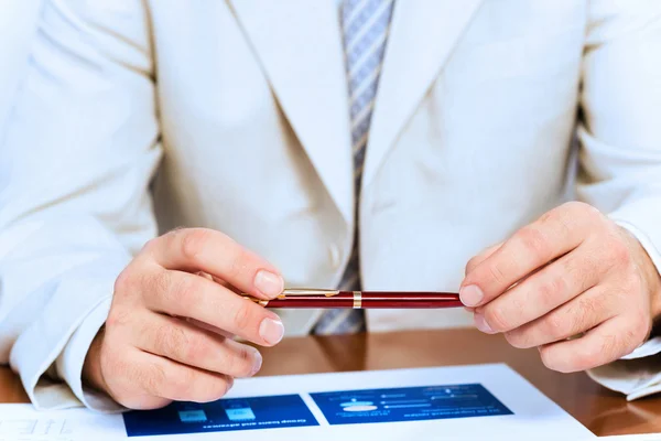 Hombre de negocios sosteniendo una pluma en la mano — Foto de Stock