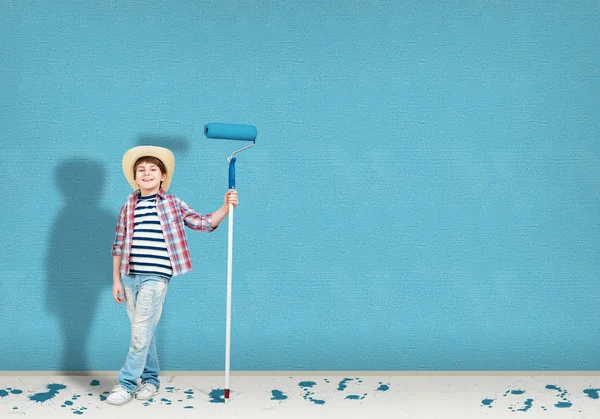 Niño en un sombrero con un rodillo para pintar — Foto de Stock