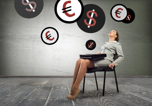 Affärskvinna sitter på stol och tittar på valutasymboler — Stockfoto