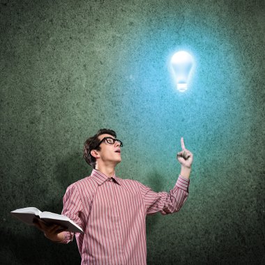 Elinde kitap tutan genç bir adam.