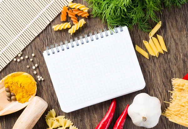 Spices and vegetables around notebook — Stock Photo, Image