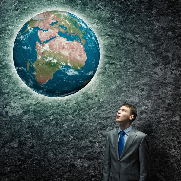 Businessman looking at Earth plane — Stock Photo, Image