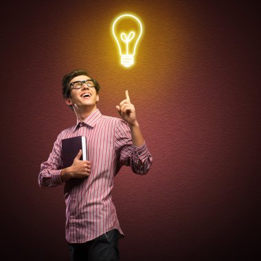 Elinde kitap tutan genç bir adam.