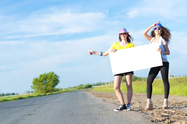 Due donne in piedi con striscione bianco — Foto Stock