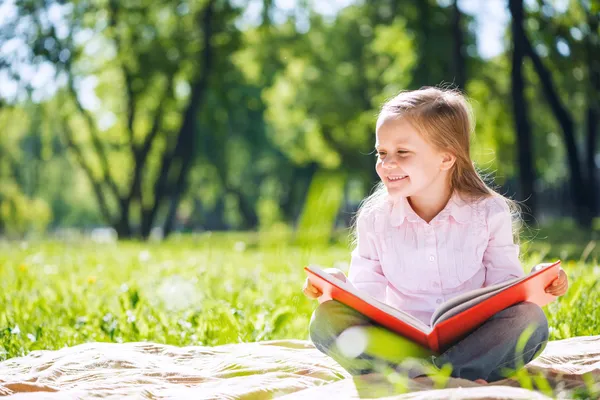 Mädchen im Sommerpark liest Buch — Stockfoto