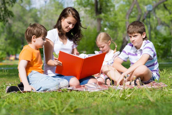 Öğretmen çocuklara kitap okur — Stok fotoğraf