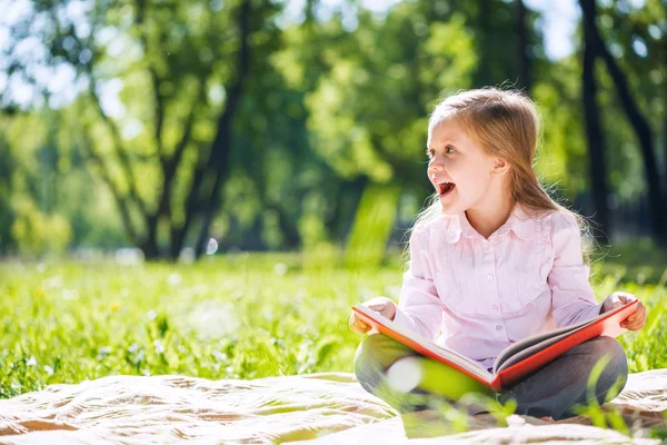 Meisje in zomer park lezen van boek — Stockfoto