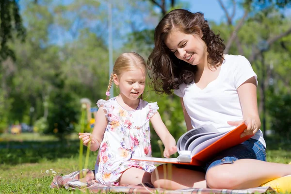 Girl and woman reading a book — Stock Photo, Image