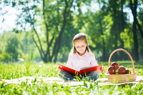 Menina no parque de verão livro de leitura — Fotografia de Stock