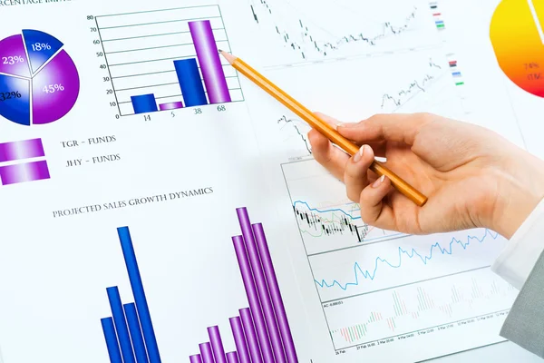 Hand pointing on financial charts — Stock Photo, Image