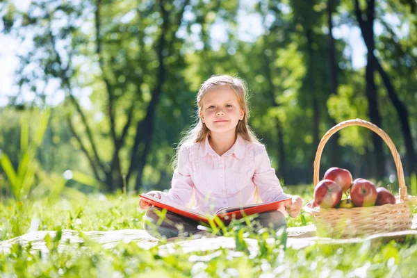 Mädchen im Sommerpark liest Buch — Stockfoto