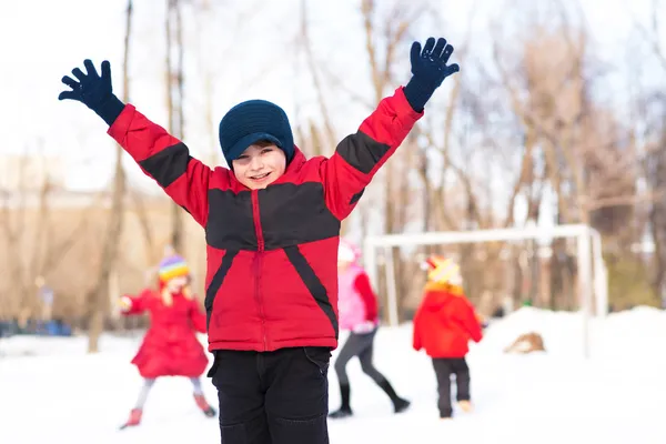 Boy in winter park raised his hand — Stock Photo, Image