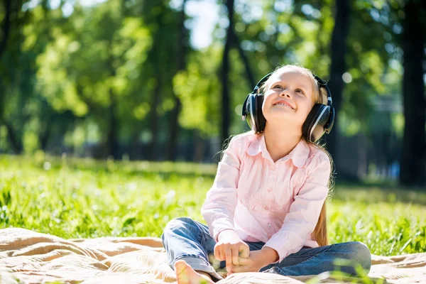 Girl in summer park listening music — Stock Photo, Image