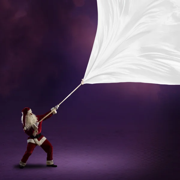 Papai Noel puxa a bandeira — Fotografia de Stock