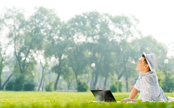 Man working in park with laptop — Stock Photo, Image