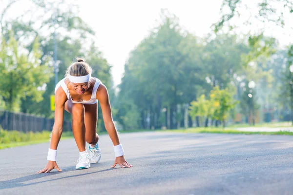 Vrouw loper in start pose — Stockfoto