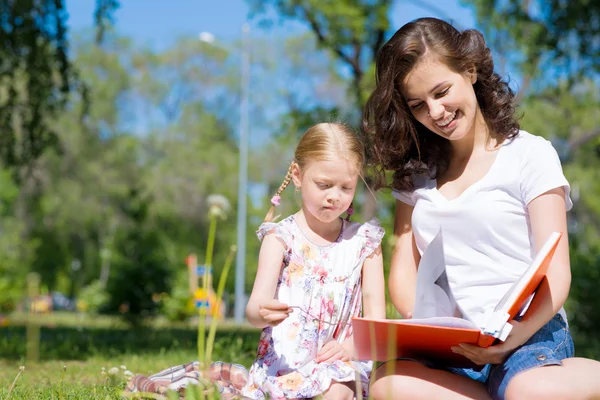 Menina e mulher lendo um livro — Fotografia de Stock