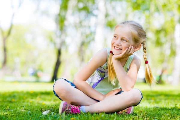 Mädchen sitzt im Gras — Stockfoto