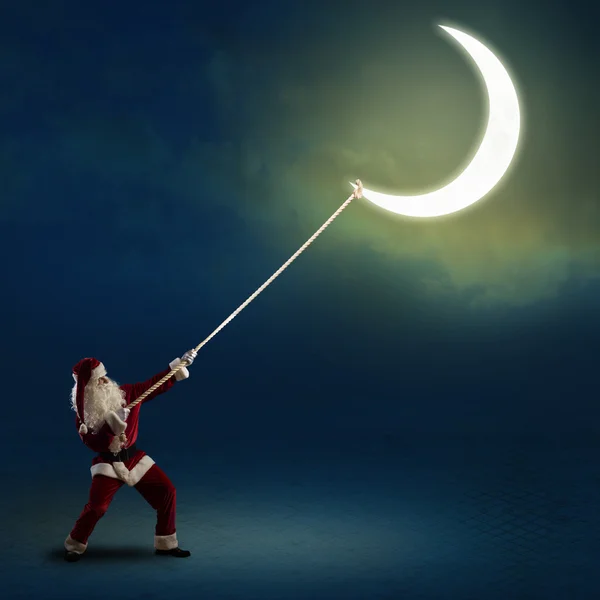 Santa Claus tira de la luna —  Fotos de Stock