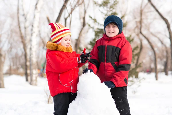 Boy and girl playing with snow — Stock Photo, Image