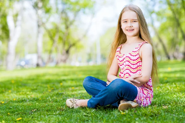 Niña sonriente en un parque — Stok fotoğraf