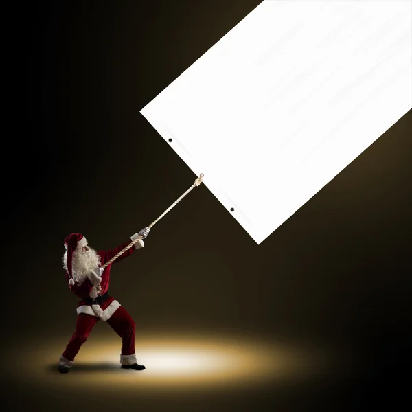 Santa Claus pulls the banner — Stock Photo, Image