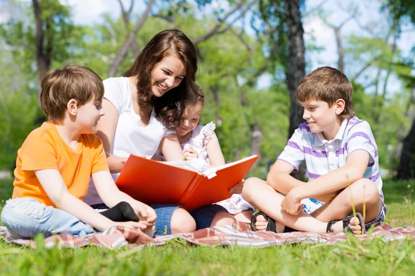 Teacher reads a book to children — Stock Photo, Image
