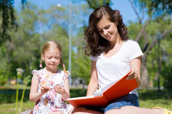 Girl and woman reading a book — Stock Photo, Image