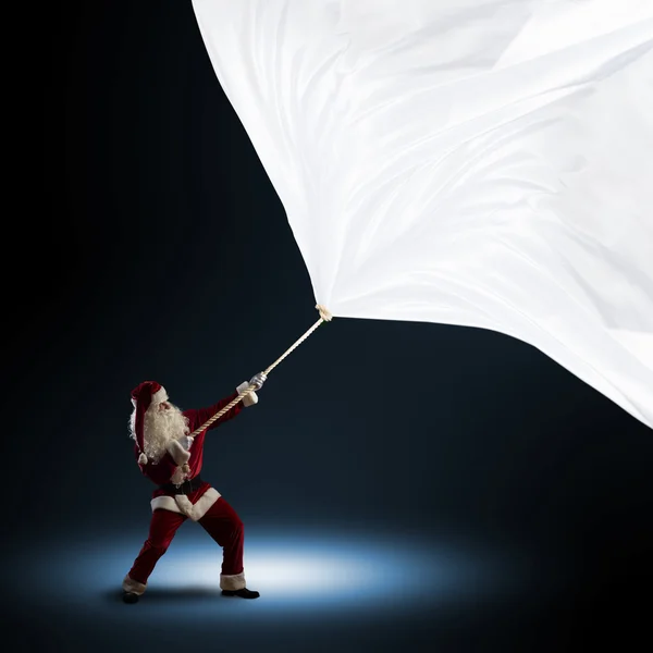 Papai Noel puxa a bandeira — Fotografia de Stock