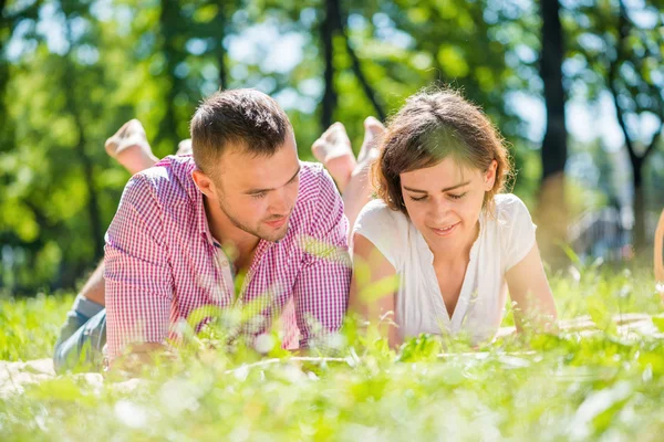 Romantic couple lying in park — Stock Photo, Image