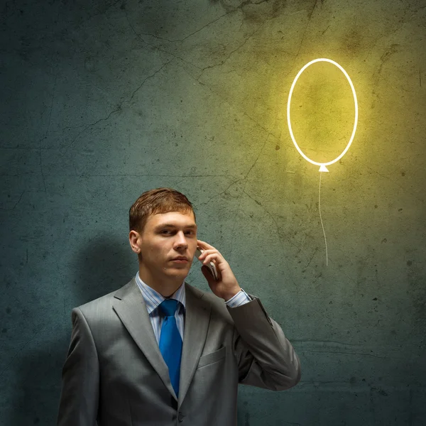 Businessman looking up at balloon — Stock Photo, Image