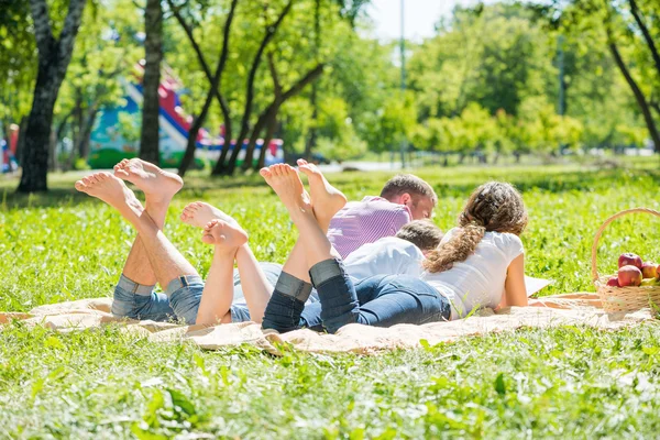 Família deitada no parque descalça — Fotografia de Stock