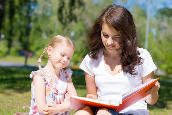 Flicka och kvinna läser en bok — Stockfoto