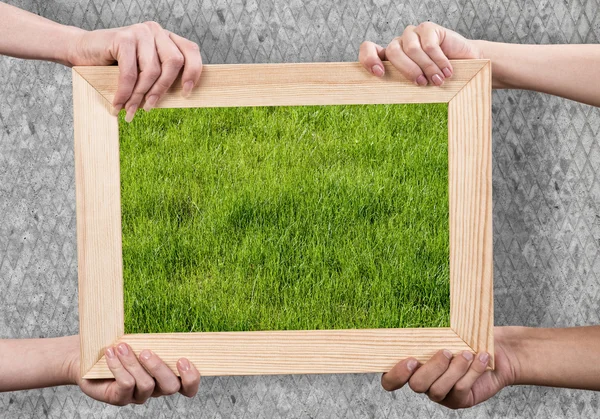 Hands holding wooden frame — Stock Photo, Image