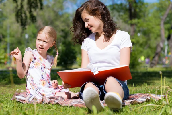 Girl and woman reading a book — Stock Photo, Image