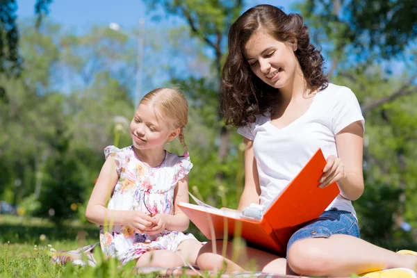 Menina e mulher lendo um livro — Fotografia de Stock