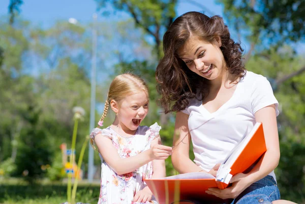 Girl and woman reading a book — Stock Photo, Image