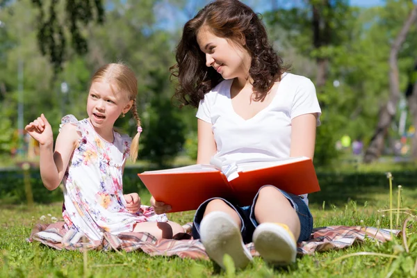 Girl and woman reading a book Stock Image