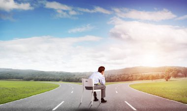 Genç işadamı bir ofis koltuğunda oturuyor.