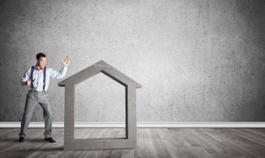 Taştan ev silueti, emlak sigortasının sembolü olarak boş odada.