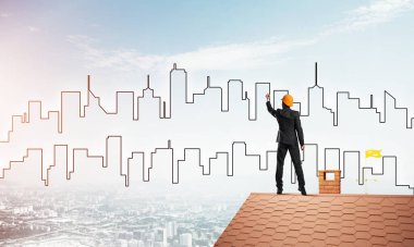 Erkek mimar mavi gökyüzüne modern şehrin siluetini çizer. Karışık ortam