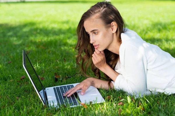 Jonge vrouw en laptop in het park — Stockfoto