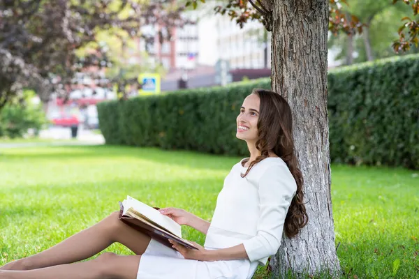 Красивая молодая женщина с блокнотом в парке — стоковое фото