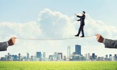 İş konsepti risk desteği ve ipte dengede duran adama yardım